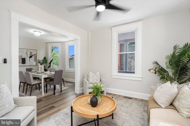 living room with visible vents, baseboards, ceiling fan, and wood finished floors