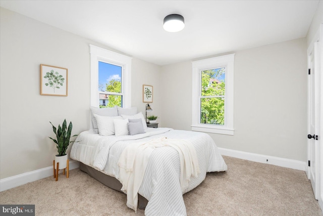 carpeted bedroom with baseboards and multiple windows