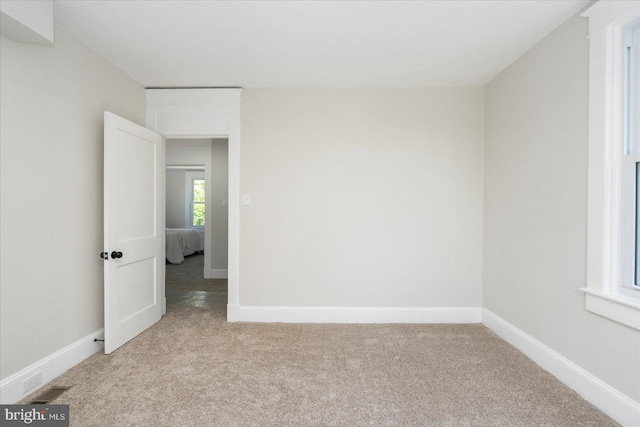 empty room featuring carpet floors and baseboards