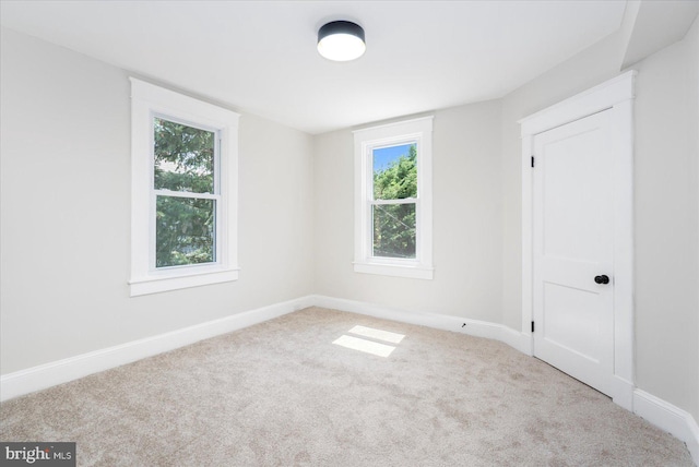 unfurnished room with carpet floors, baseboards, and a healthy amount of sunlight