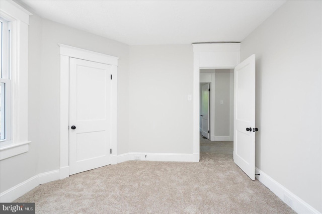 unfurnished bedroom featuring baseboards and carpet