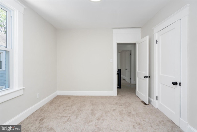 unfurnished bedroom with carpet flooring and baseboards