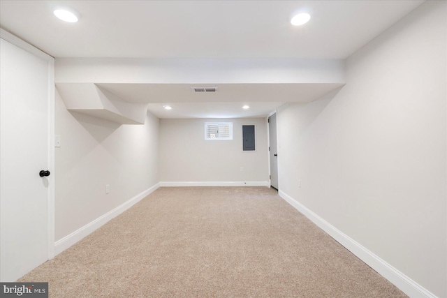 finished basement featuring electric panel, visible vents, baseboards, light carpet, and recessed lighting