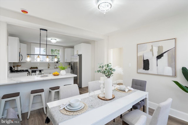 dining space with dark wood-type flooring and baseboards
