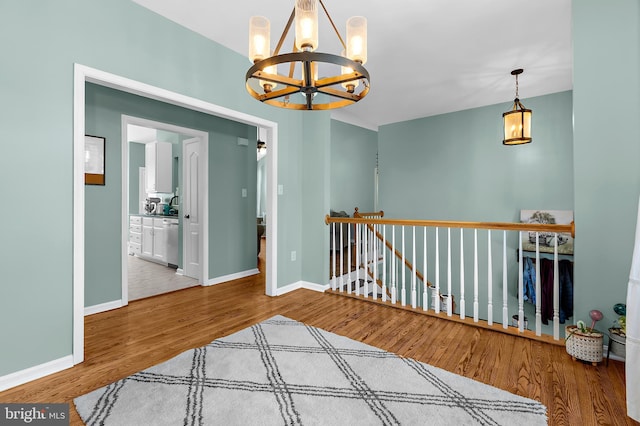 11312 Rawhide Rd, Lusby, MD 20657 - spare room featuring baseboards, a notable chandelier, and wood finished floors