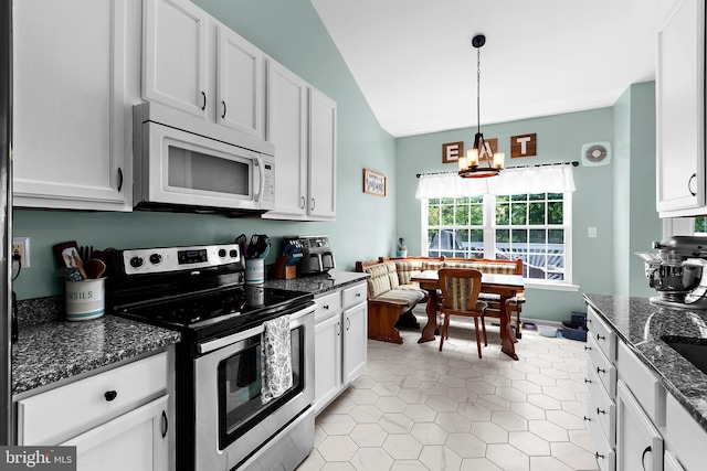 11312 Rawhide Rd, Lusby, MD 20657 - kitchen with stainless steel range with electric cooktop, a chandelier, white cabinetry, white microwave, and vaulted ceiling