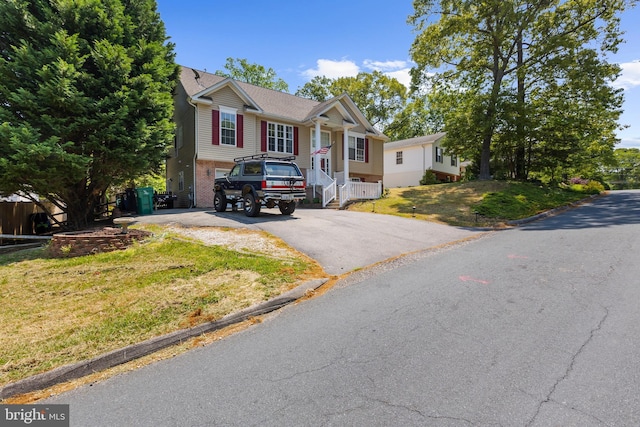 11312 Rawhide Rd, Lusby, MD 20657 - view of front of home featuring brick siding, a front lawn, and aphalt driveway