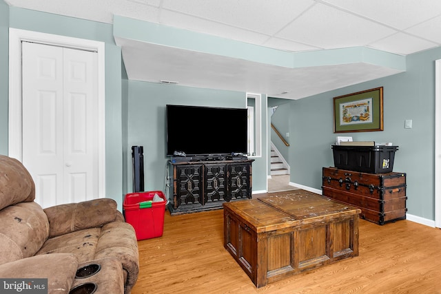 11312 Rawhide Rd, Lusby, MD 20657 - living area featuring light wood-type flooring, baseboards, a drop ceiling, and stairway
