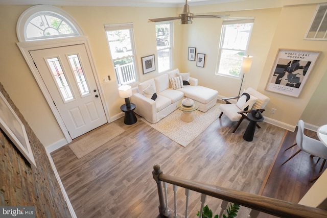 foyer entrance with baseboards, wood finished floors, and visible vents