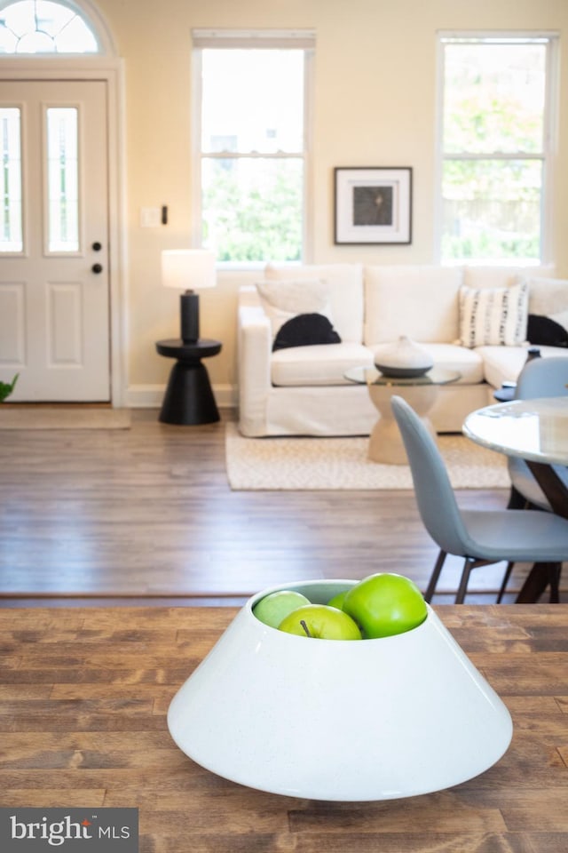 living area with baseboards and wood finished floors