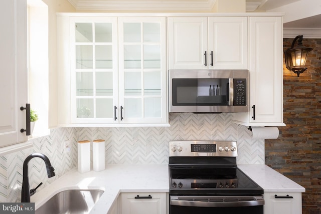 kitchen with stainless steel appliances, white cabinetry, and a sink