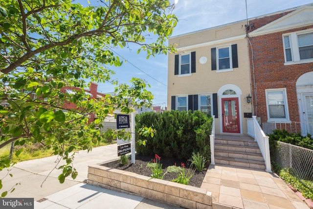 townhome / multi-family property with brick siding and fence