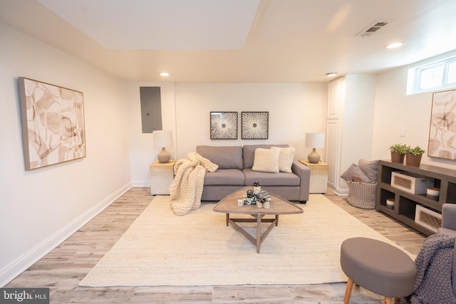 living room with light wood-type flooring, electric panel, recessed lighting, and visible vents