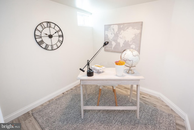 home office with baseboards and wood finished floors