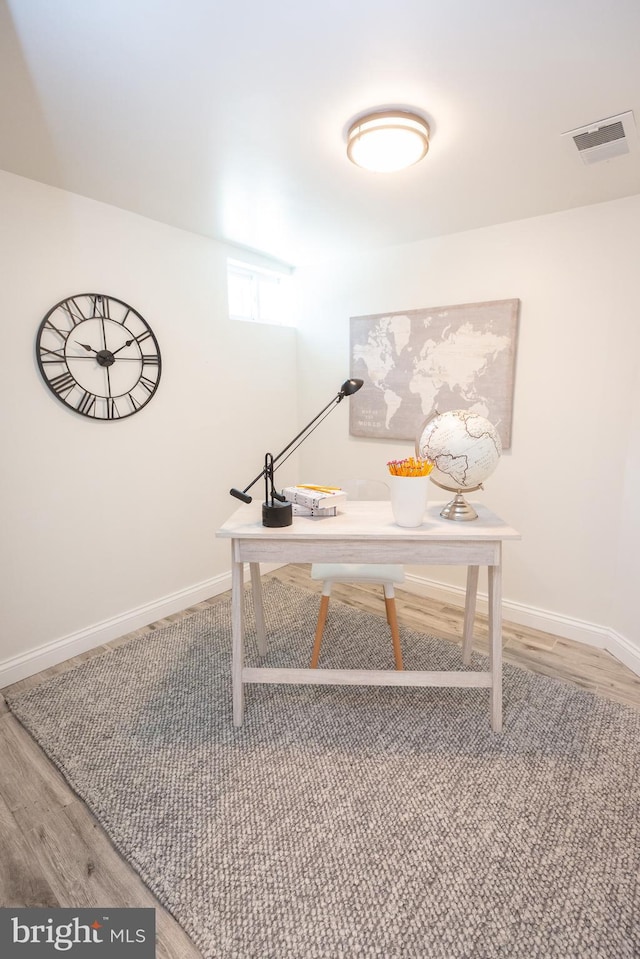 office area with baseboards, wood finished floors, and visible vents