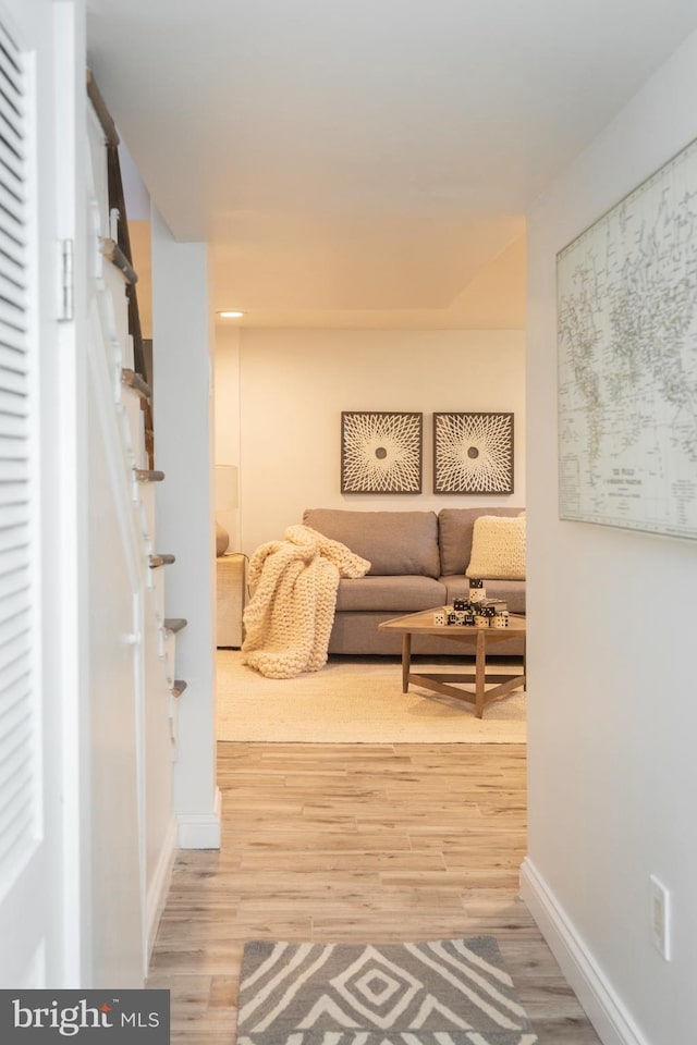 hallway featuring baseboards and light wood finished floors