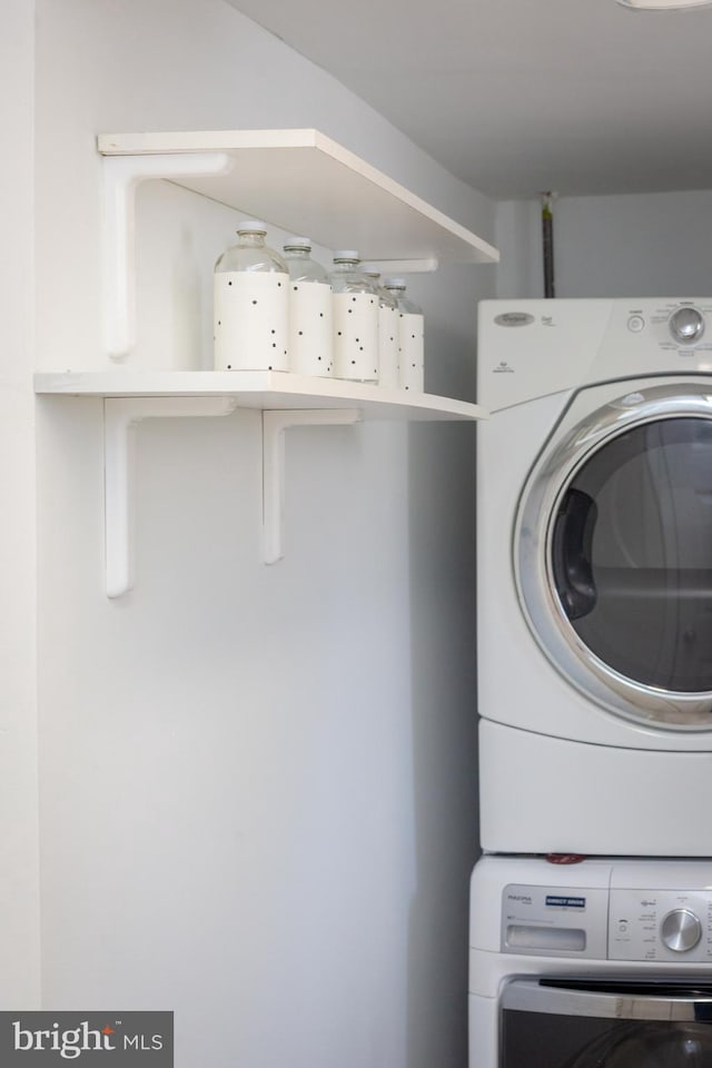 clothes washing area featuring laundry area and stacked washer and clothes dryer