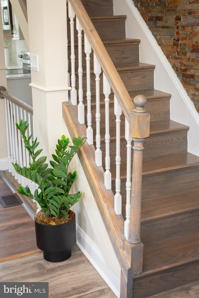 stairway featuring baseboards and wood finished floors