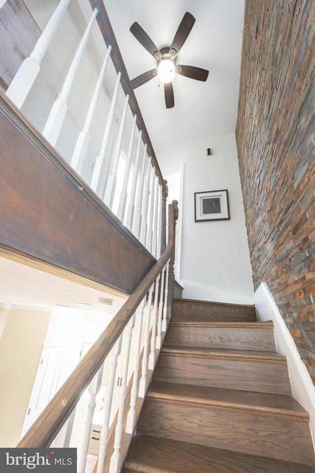 stairway with baseboards, ceiling fan, and lofted ceiling