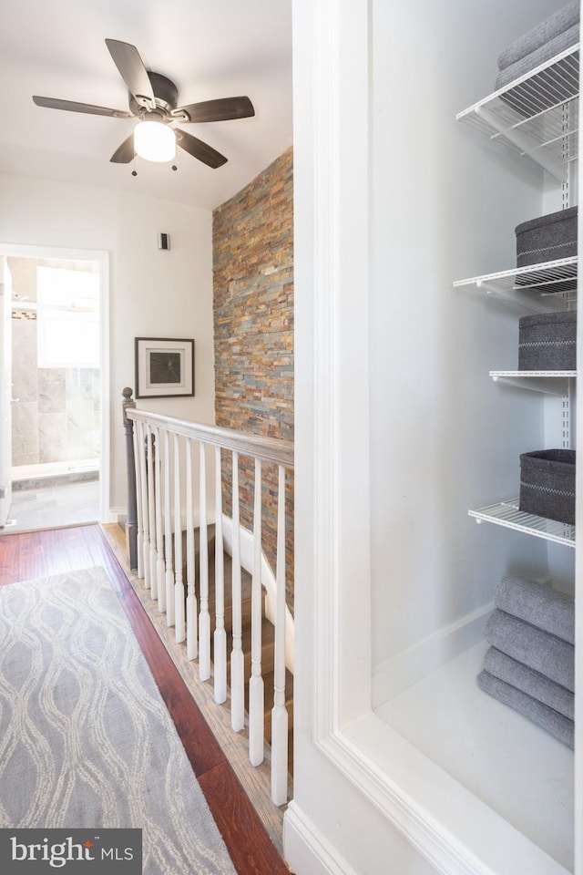 stairs featuring ceiling fan and wood finished floors