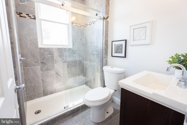 bathroom with toilet, a shower stall, and vanity