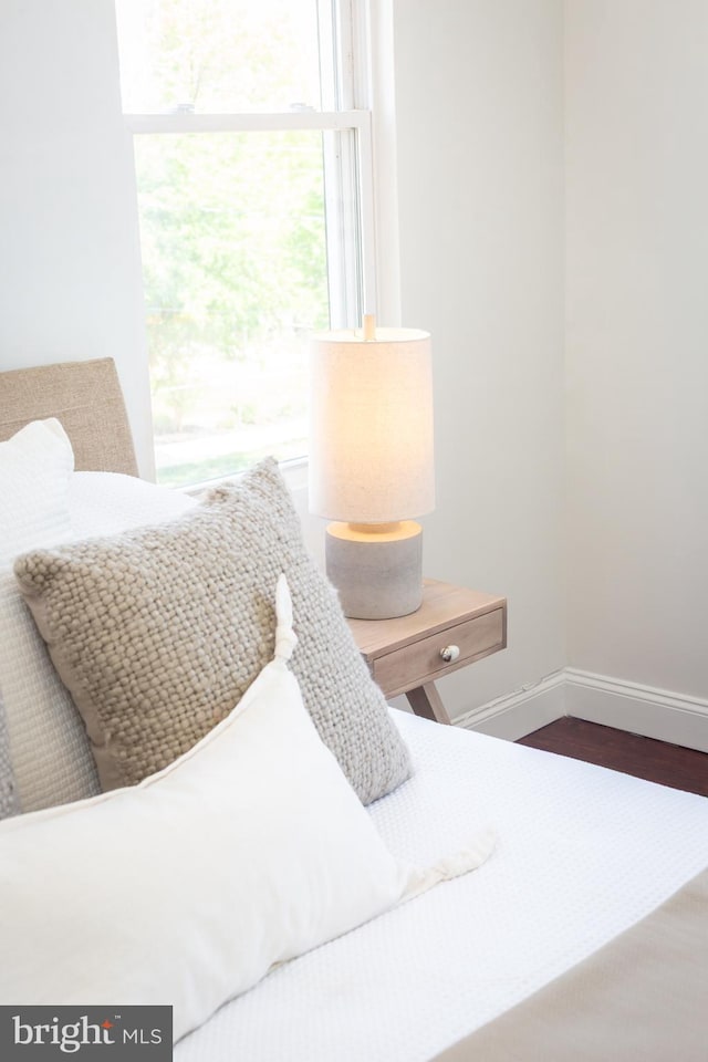 bedroom featuring baseboards and dark wood-style flooring