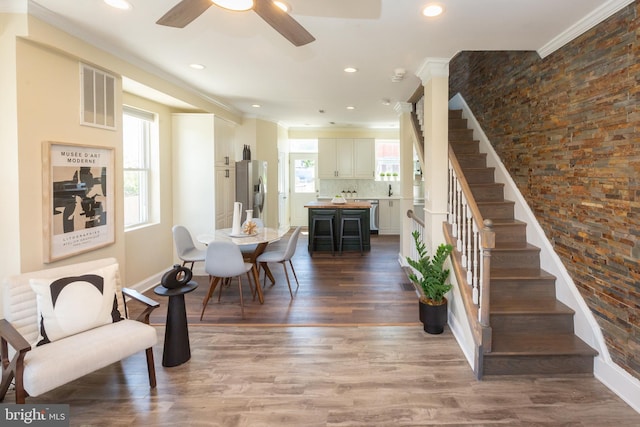 interior space with visible vents, a ceiling fan, stairway, and ornamental molding