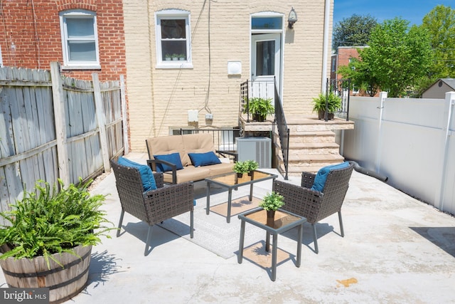 view of patio with an outdoor living space, central AC unit, and a fenced backyard