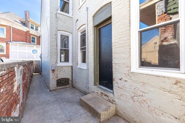 doorway to property featuring brick siding