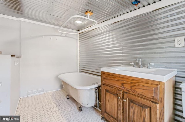 full bathroom with visible vents, a freestanding tub, and vanity