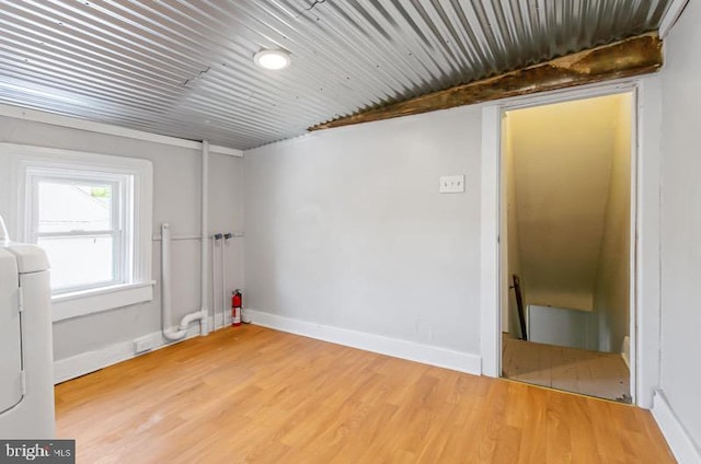 spare room featuring baseboards and light wood-type flooring