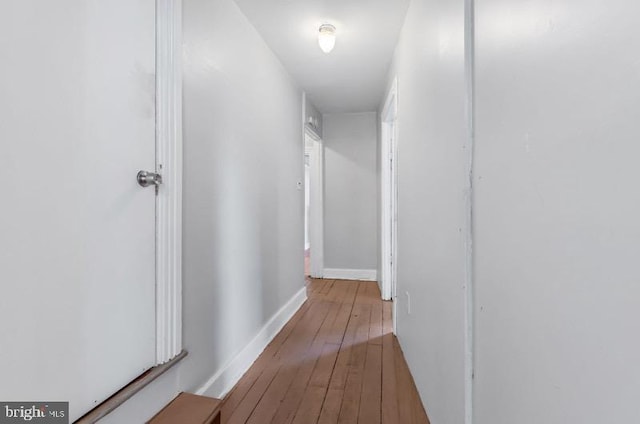 hall with baseboards and hardwood / wood-style floors