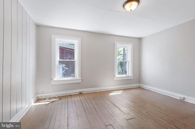 empty room with baseboards and hardwood / wood-style floors