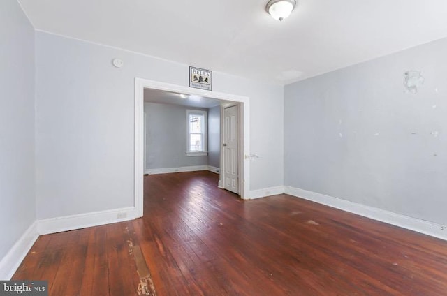 empty room with baseboards and hardwood / wood-style flooring