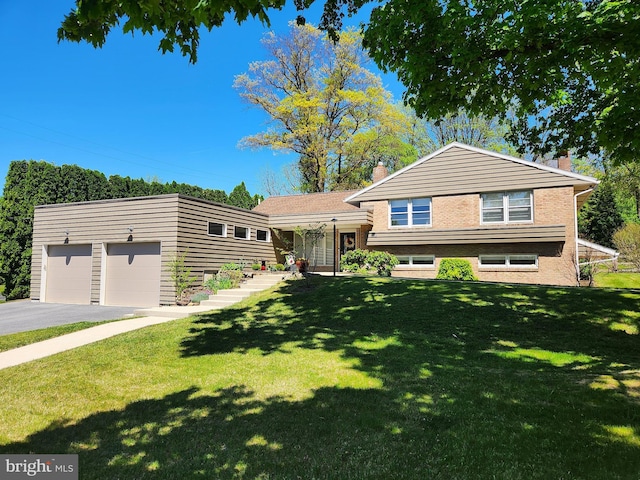 tri-level home featuring brick siding, a front lawn, driveway, and a chimney