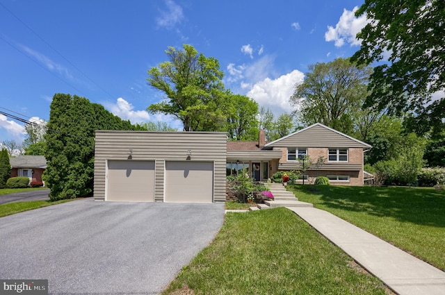 1515 Rockland St, Reading, PA 19604 - split level home with an attached garage, driveway, a front yard, and a chimney