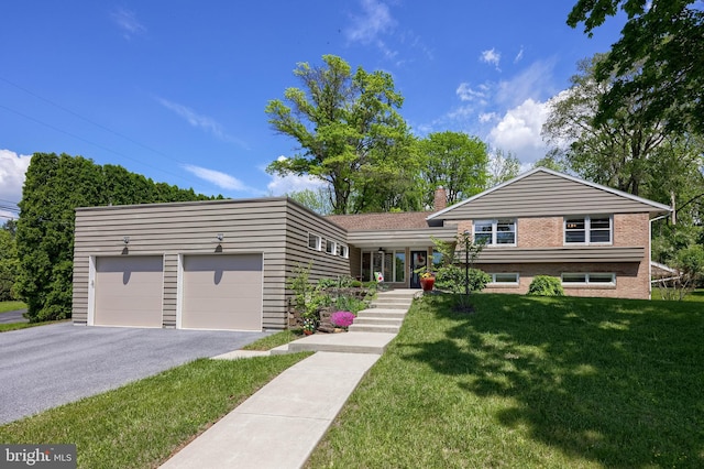 1515 Rockland St, Reading, PA 19604 - split level home with a front lawn, driveway, an attached garage, a chimney, and brick siding