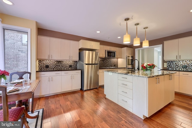 1515 Rockland St, Reading, PA 19604 - kitchen featuring stainless steel appliances, backsplash, light wood-style flooring, pendant lighting, and dark stone countertops