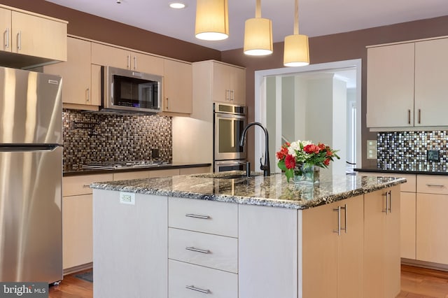 1515 Rockland St, Reading, PA 19604 - kitchen with appliances with stainless steel finishes, dark stone countertops, decorative backsplash, a kitchen island with sink, and pendant lighting