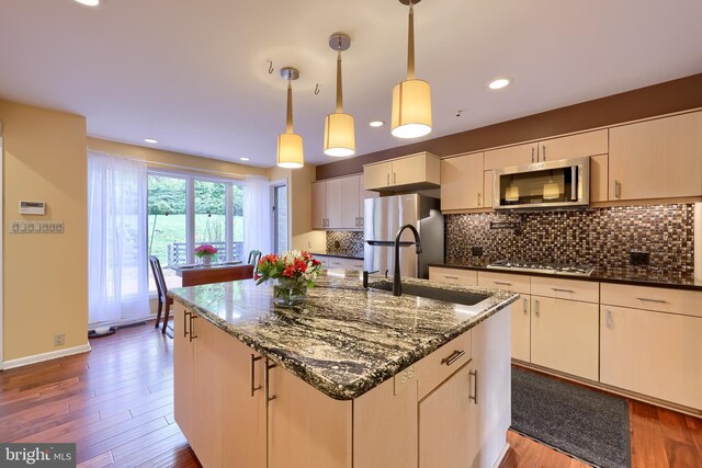 1515 Rockland St, Reading, PA 19604 - kitchen featuring stainless steel appliances, a sink, backsplash, dark stone countertops, and wood finished floors