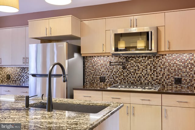 1515 Rockland St, Reading, PA 19604 - kitchen featuring stainless steel appliances, tasteful backsplash, dark stone countertops, a sink, and light brown cabinetry