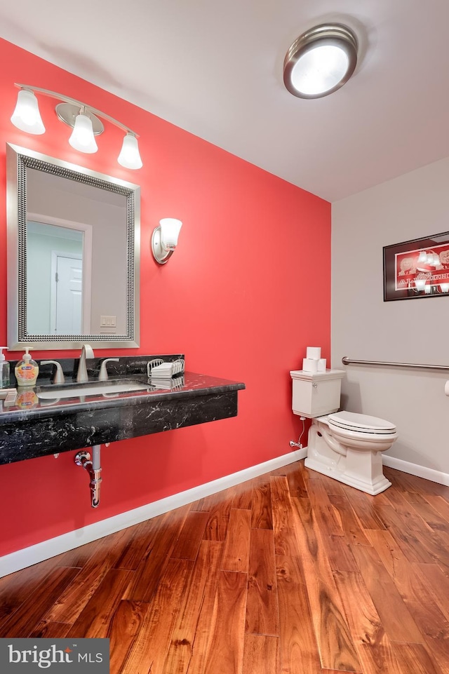 1515 Rockland St, Reading, PA 19604 - half bathroom featuring wood finished floors, a sink, toilet, and baseboards