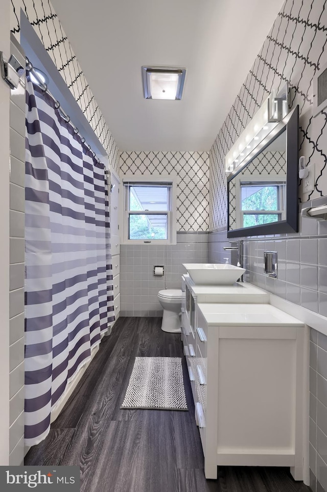 1515 Rockland St, Reading, PA 19604 - full bath with tile walls, toilet, wood finished floors, vanity, and wallpapered walls