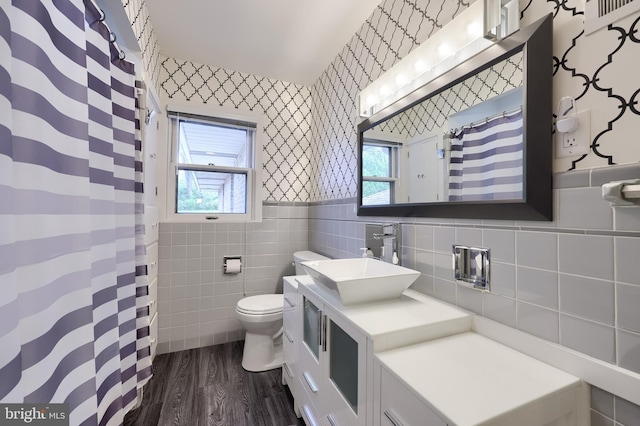 1515 Rockland St, Reading, PA 19604 - bathroom with tile walls, wallpapered walls, wood finished floors, toilet, and vanity