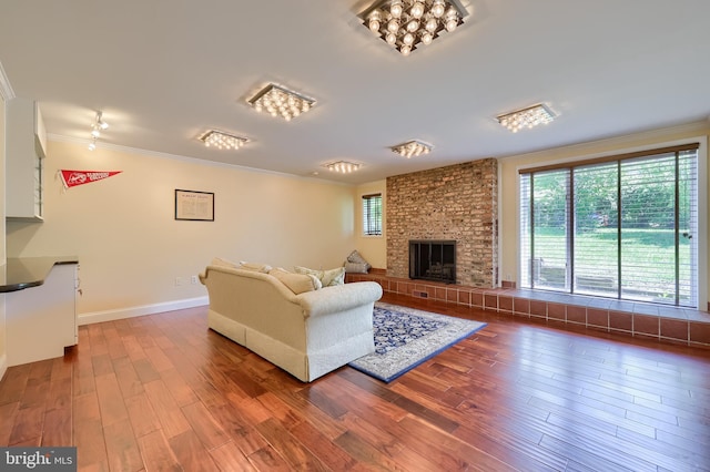 1515 Rockland St, Reading, PA 19604 - living room with wood finished floors, crown molding, a brick fireplace, and baseboards