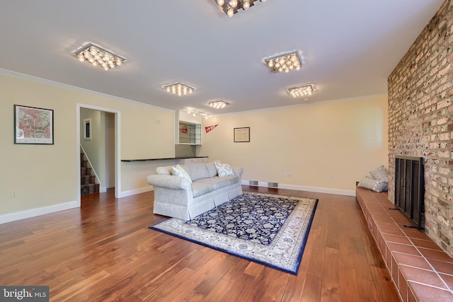 1515 Rockland St, Reading, PA 19604 - living room featuring stairway, ornamental molding, a brick fireplace, wood finished floors, and baseboards