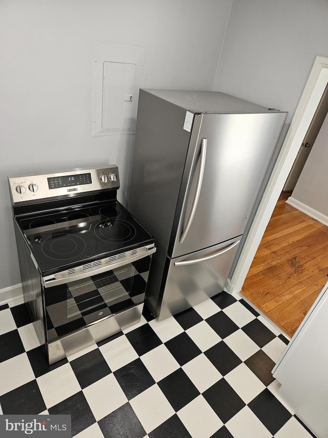 kitchen with tile patterned floors, appliances with stainless steel finishes, baseboards, and electric panel