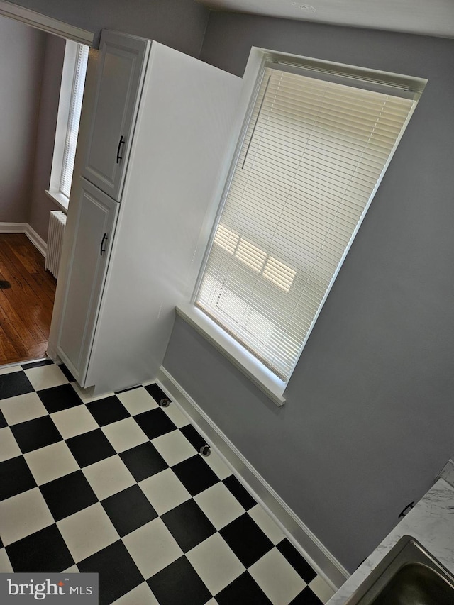 interior space featuring baseboards, tile patterned floors, and radiator heating unit