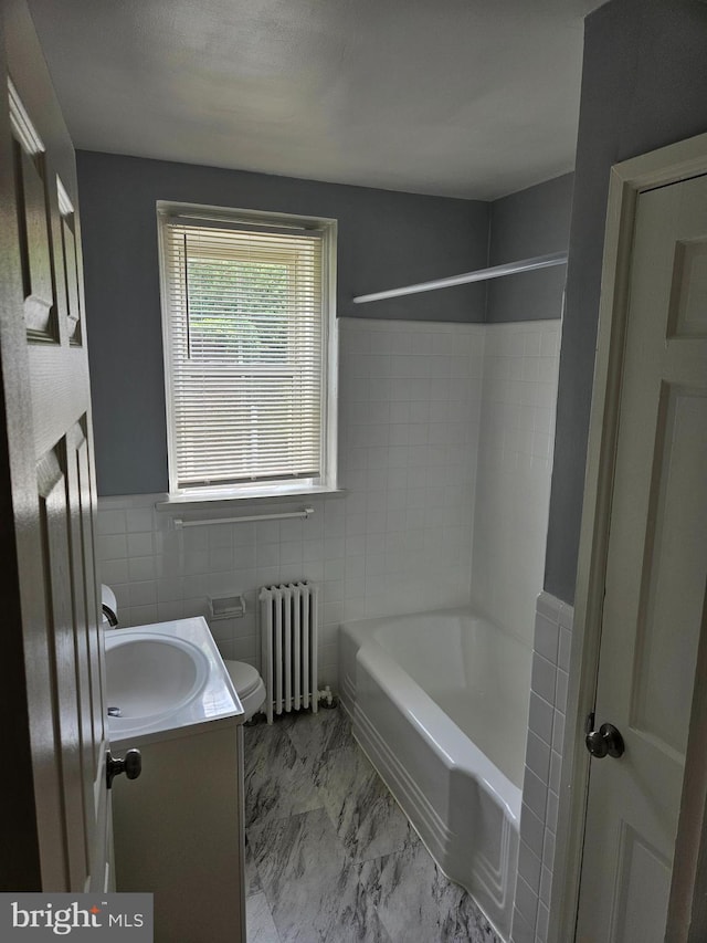 full bath featuring tile walls, a wainscoted wall, vanity, toilet, and radiator