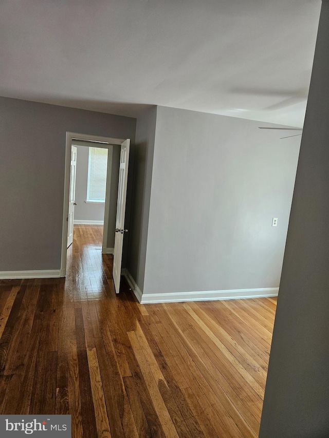 empty room featuring baseboards and hardwood / wood-style flooring
